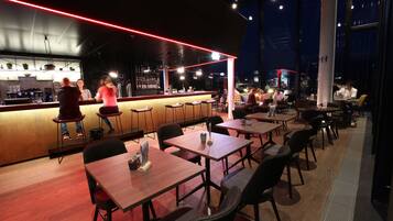 Ein modernes Restaurant mit Bar, Holztischen und -stühlen.