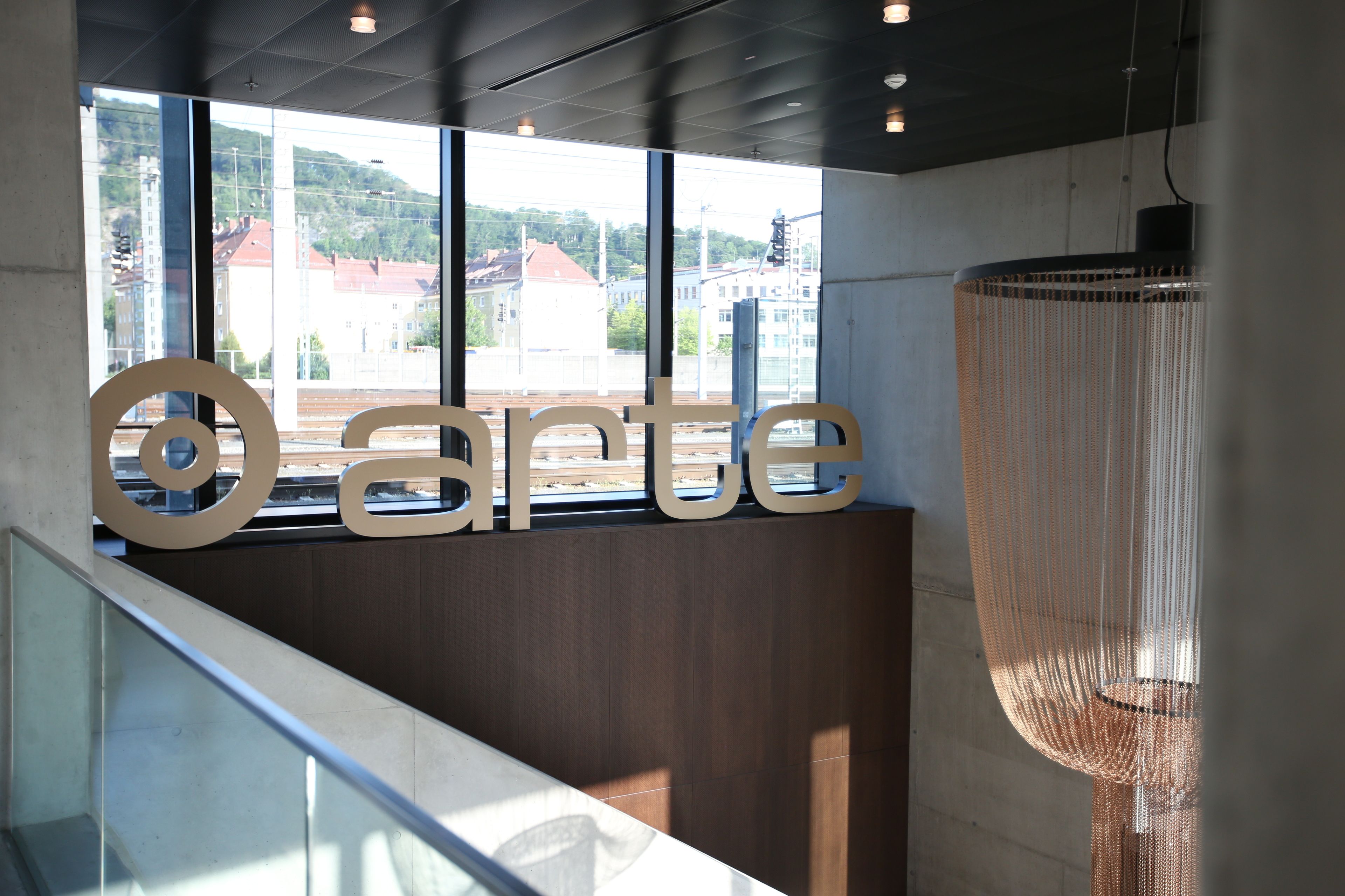 En modern inredning med ett stort fönster, en hängande lampa och ordet ”arte” tydligt synligt.