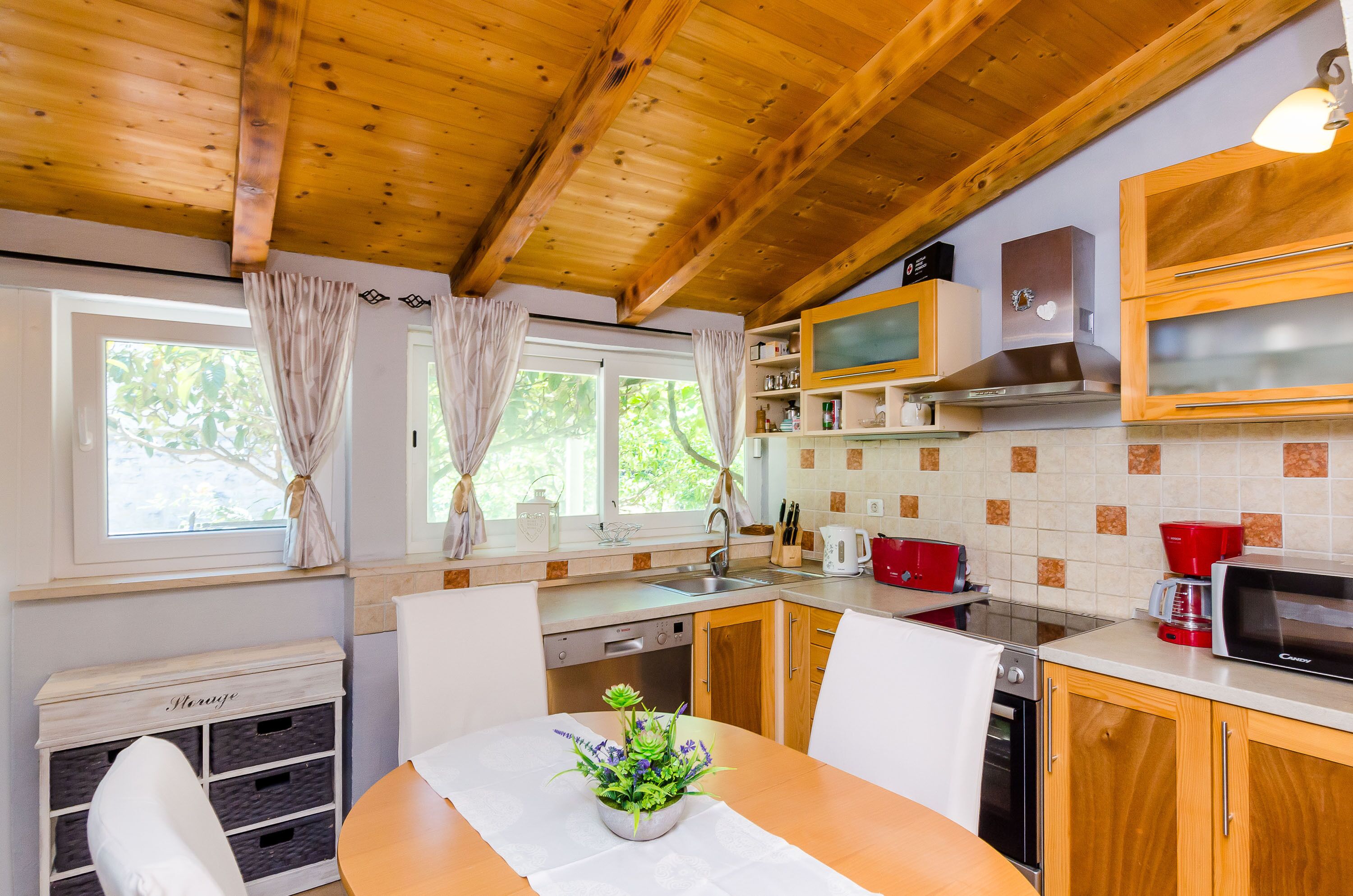 A kitchen with wooden cabinets, a microwave, a stove, and a sink.