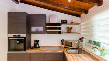 Studio apartment with patio | Cocina privada | Frigorífico grande, microondas, horno y placa de cocina