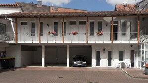 A two-story building with a covered entrance and a car parked inside. - Hotel Holländischer Hof (Lich)