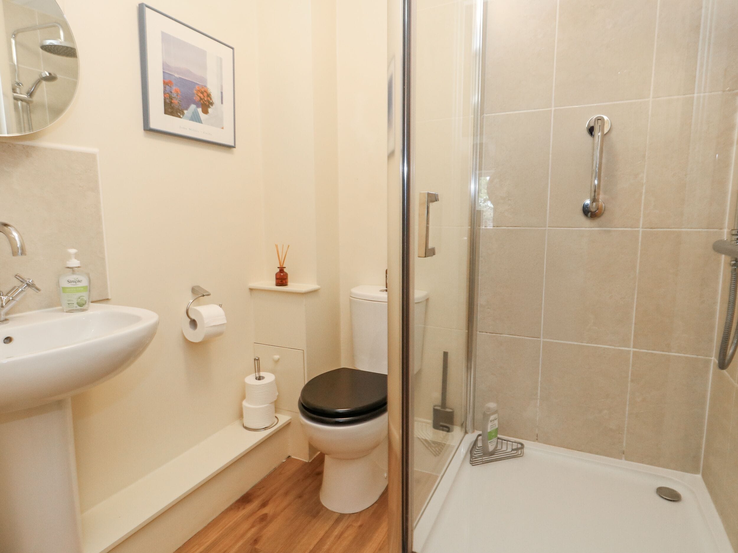 Et badeværelse med vask, toilet og brusebad.