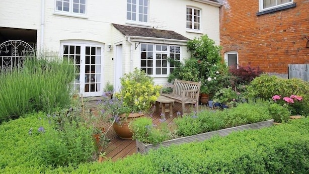 A two-story house with a garden in front. - The Mews Cottage (Salisbury)