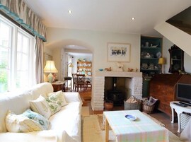Una sala acogedora con chimenea, un sofá, una mesa de comedor y un televisor.