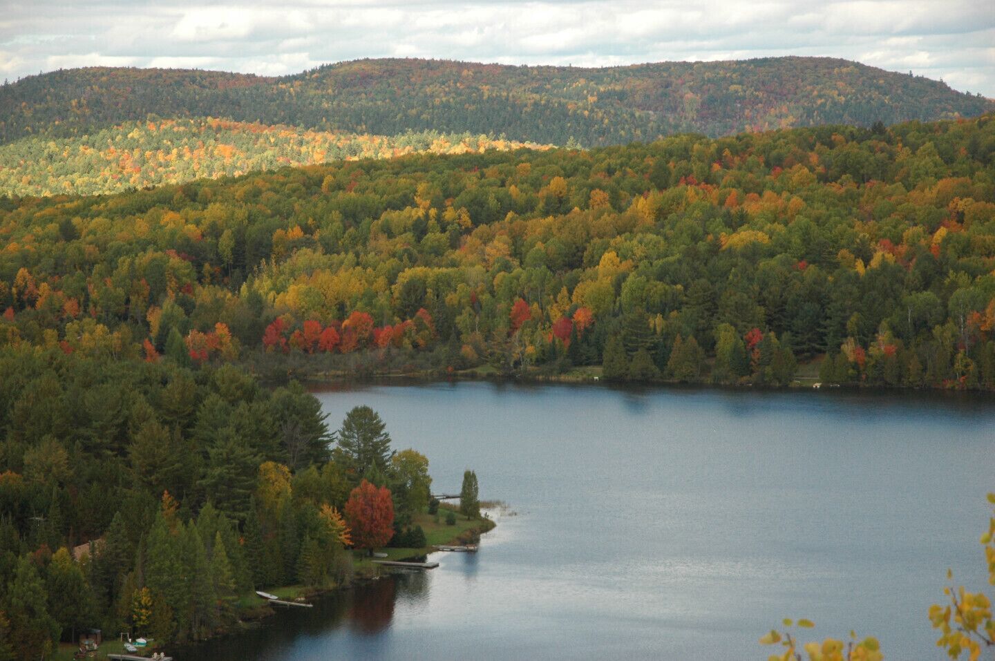 A lake surrounded by dense forest with autumn foliage.