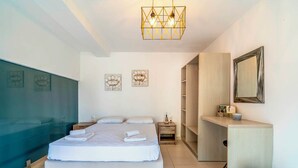 Een moderne slaapkamer met een groot bed, nachtkastjes, een bureau en een kledingkast.