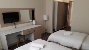 A hotel room with two beds, a desk, a chair, a TV, a mirror, and a wardrobe. - Selahaddin Eyyubi Uygulama Oteli (Istanbul)