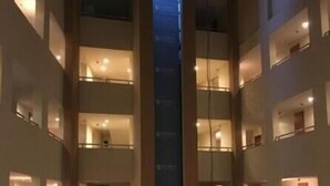 Hotelinnenraum mit mehreren Ebenen, einem zentralen Aufzugsschacht und zahlreichen Balkonen, gestaltet im modernen Stil.