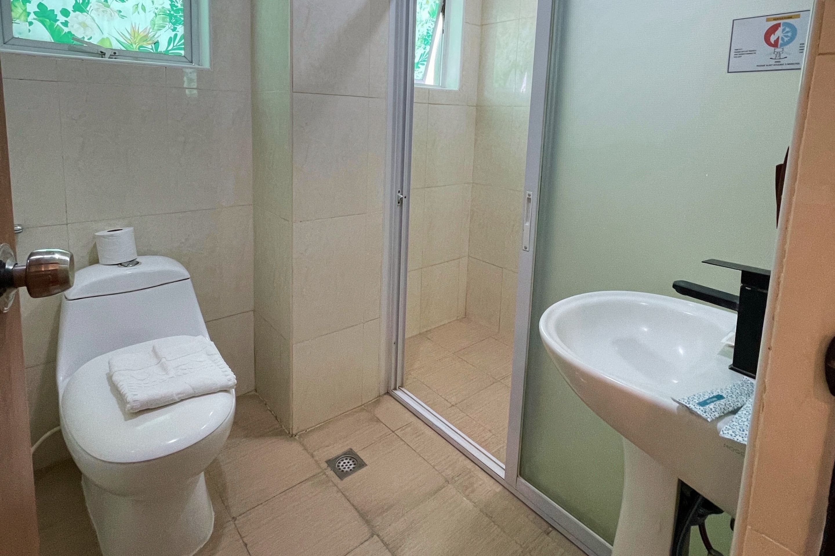 Een badkamer met toilet, wastafel en douche.
