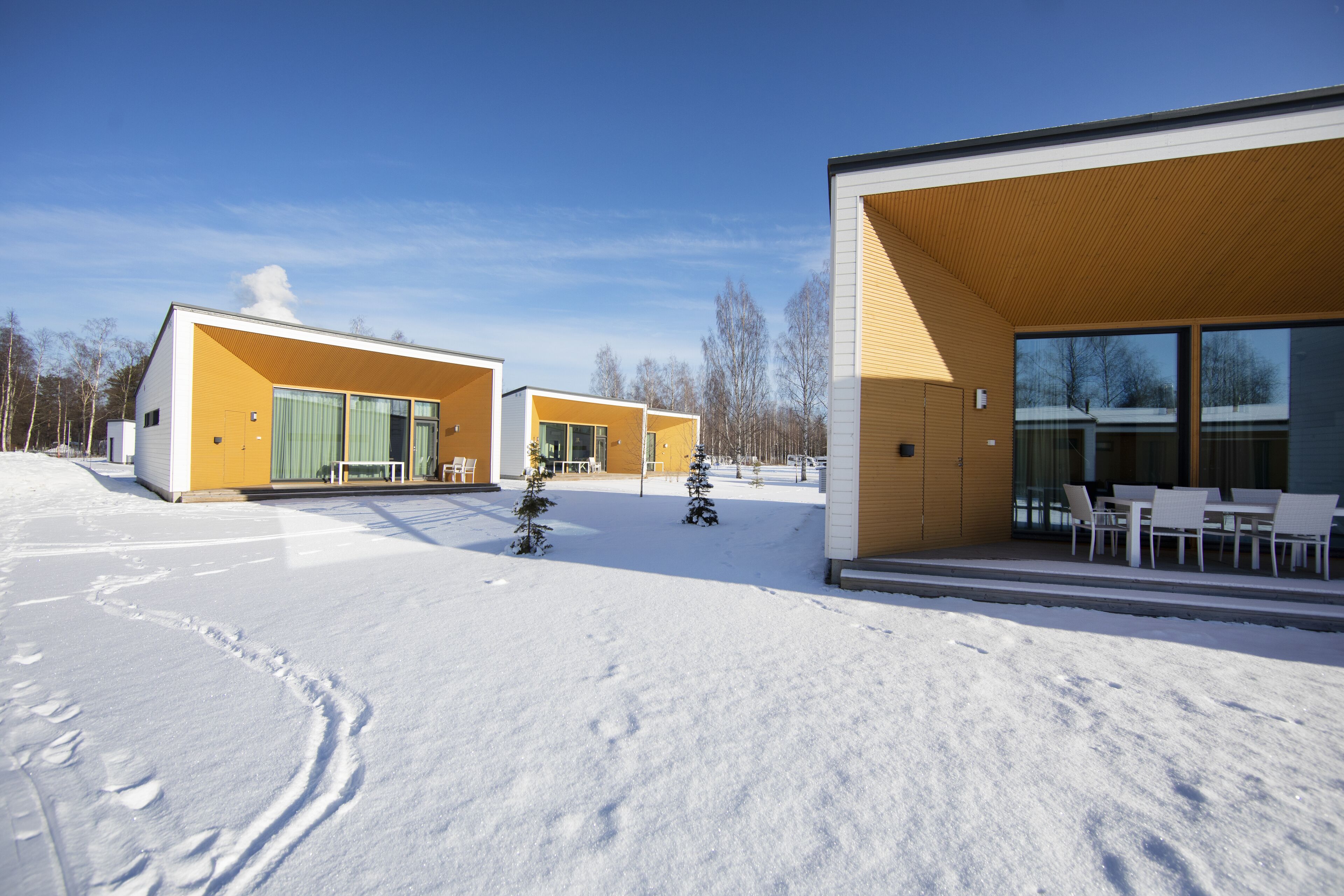 A modern building with large windows and a covered outdoor seating area.