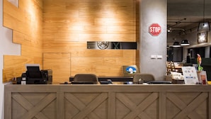 Una recepción con detalles de madera, un reloj y un cartel que dice 'Don't Stop Fighting'.