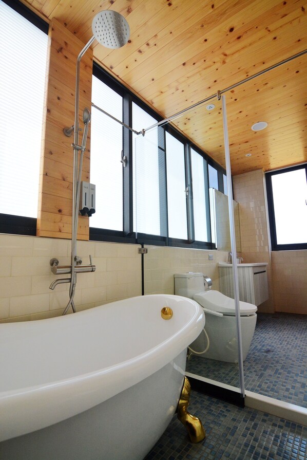 A modern bathroom with a freestanding bathtub, a glass shower enclosure, and a large window providing natural light. - Say Yeah Inn (Magong)