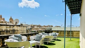 A rooftop terrace with outdoor furniture, a view of the cityscape, and a satellite dish. - Casa Birmula (Cospicua)