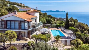 Ein großes Haus mit Swimmingpool, Balkon und Meerblick.