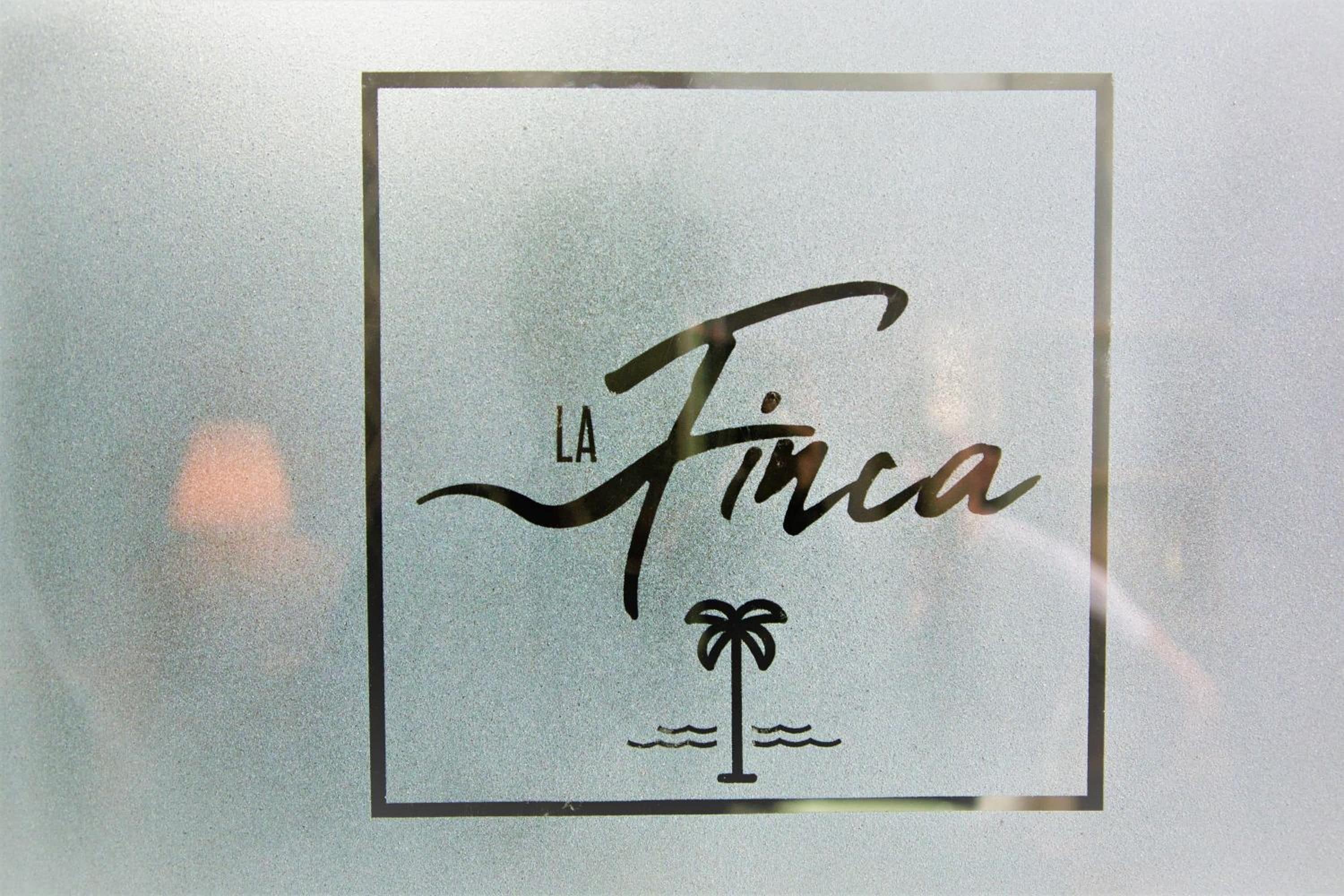 A logo with the text 'LA Finca' and a palm tree symbol.