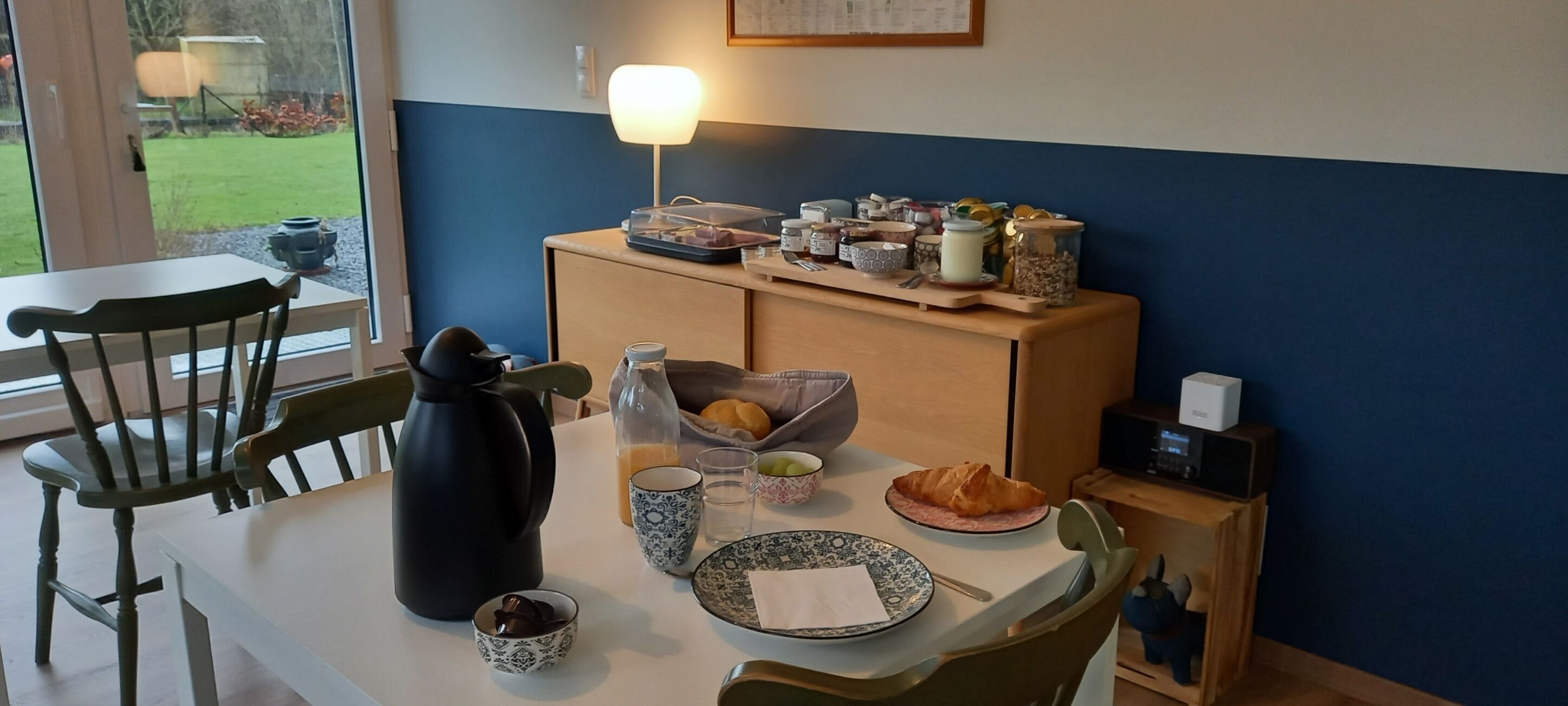 Une table de petit-déjeuner avec une machine à café, des croissants et divers autres aliments pour le petit-déjeuner.