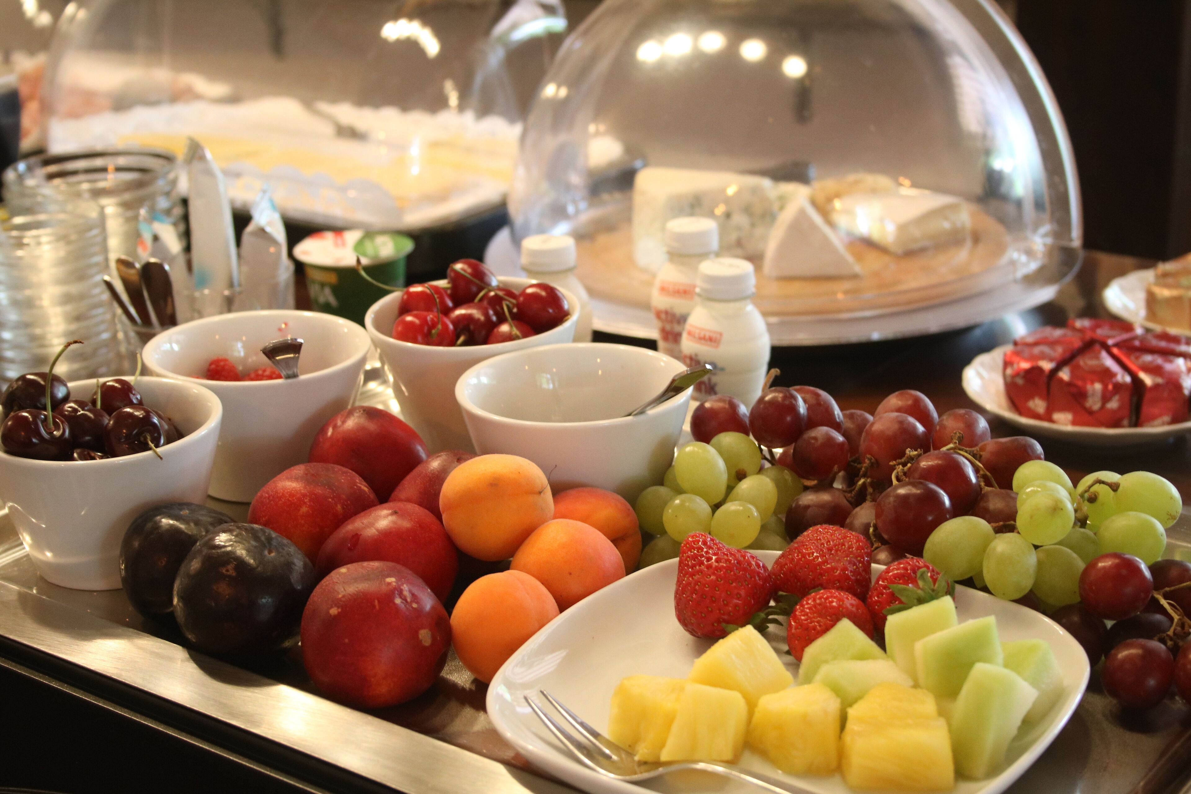 A buffet with various fruits and desserts.
