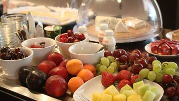 A buffet with various fruits and desserts.