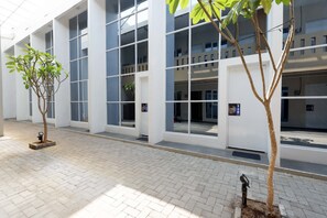 A modern building with large windows and a paved walkway. - RedDoorz Plus near Paragon Mall Semarang (Semarang)
