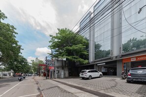 A modern building with a Samsung store, a Xiaomi store, and a sign for 'Lodging 99'.