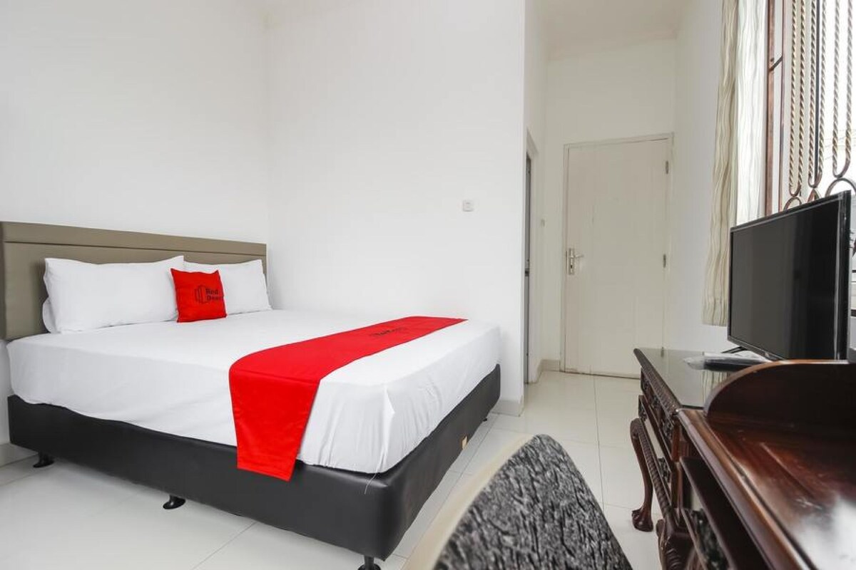 Ein Hotelzimmer mit Bett, Fernseher und Tür.
