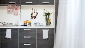 Una cocina moderna con armarios oscuros, una encimera blanca y un jarrón con flores.