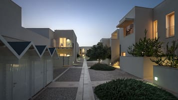 Un bâtiment moderne doté d’une allée centrale, de petits arbres et d’une zone recouverte de gravier.