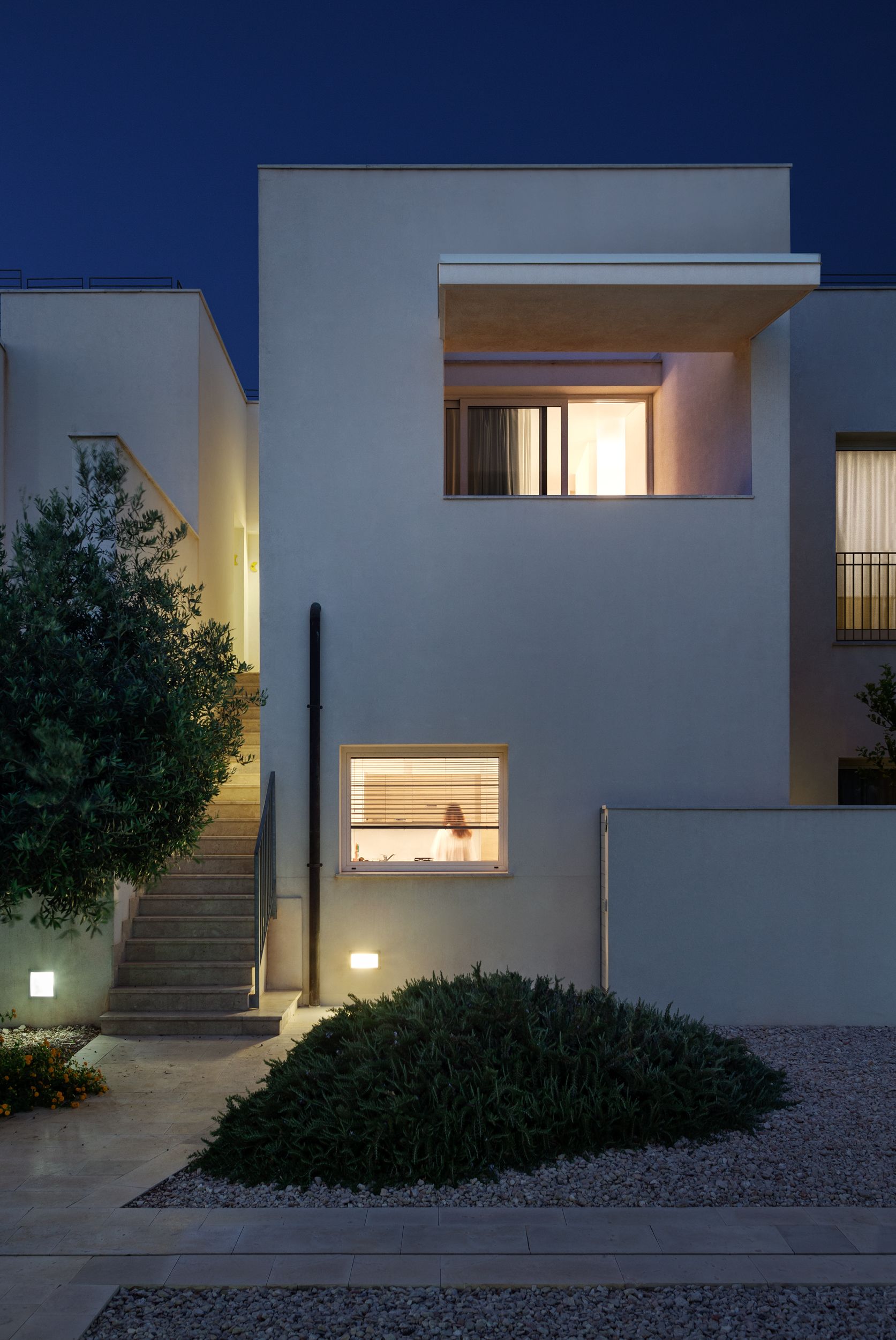 Un bâtiment moderne doté d’un escalier, d’une petite fenêtre et d’une entrée bien éclairée.