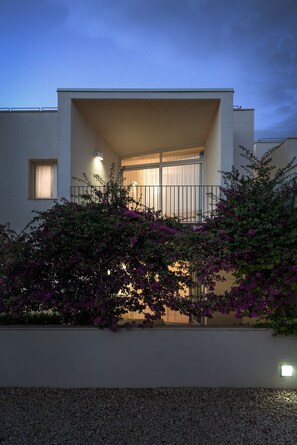 A modern building with a balcony, a small window, and a wall-mounted light. - Cala Palme (Lampedusa)