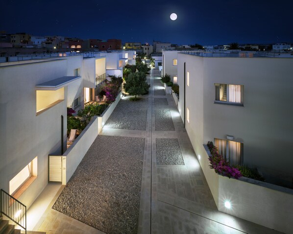 A modern hotel corridor with a central pathway, small windows, and outdoor plants. - Cala Palme (Lampedusa)