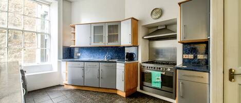 A kitchen with a stove, oven, and cabinets.