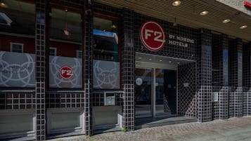 La façade d’un hôtel, ornée d’un logo F2 bien visible, avec un revêtement extérieur en carreaux et une entrée facilement identifiable.