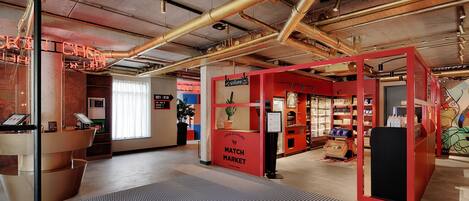 A modern interior with exposed ductwork, a reception desk, and a 'Match Market' sign.