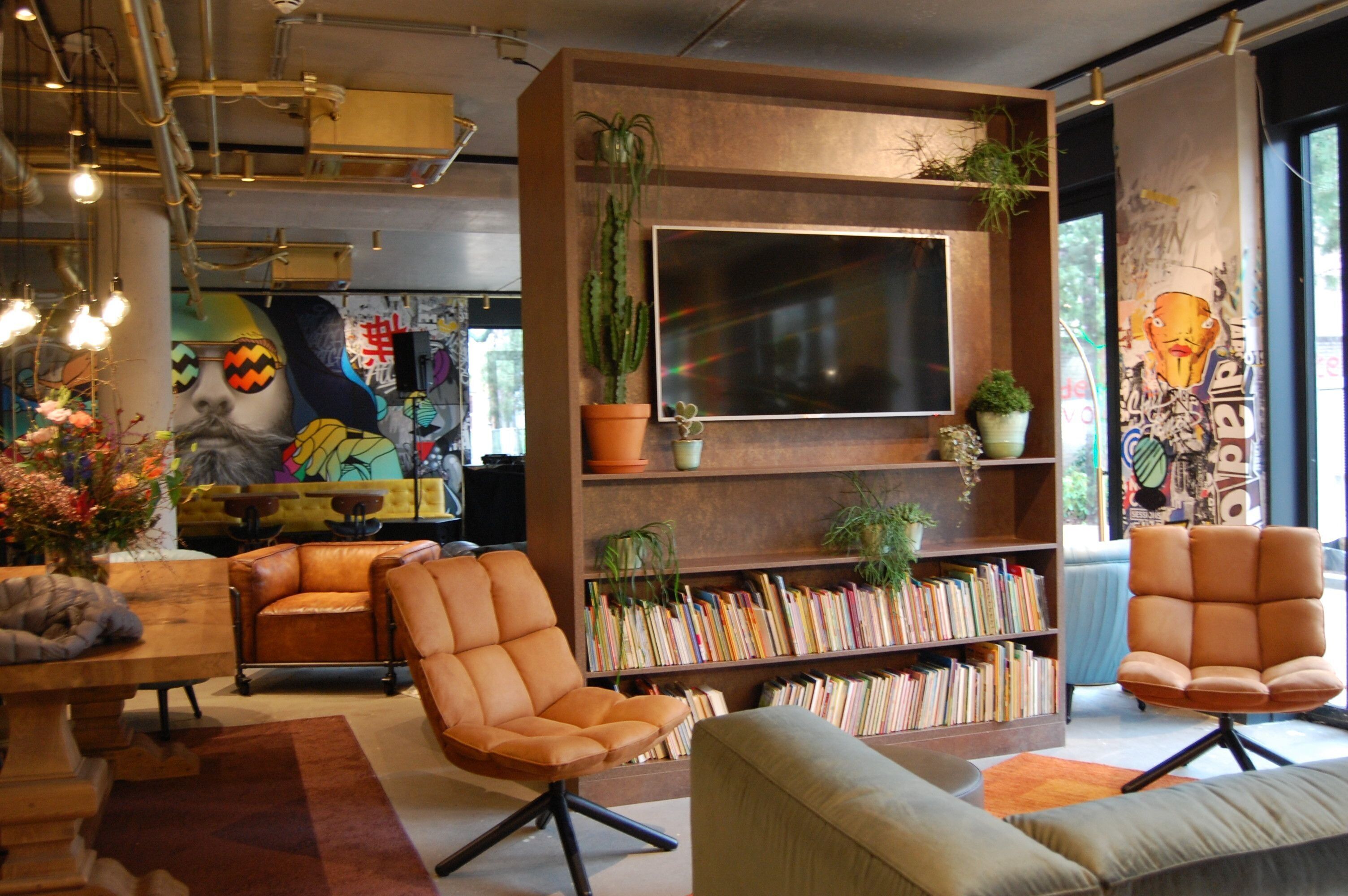 Una sala de estar moderna con sillones de cuero, una estantería y un televisor de pantalla plana.