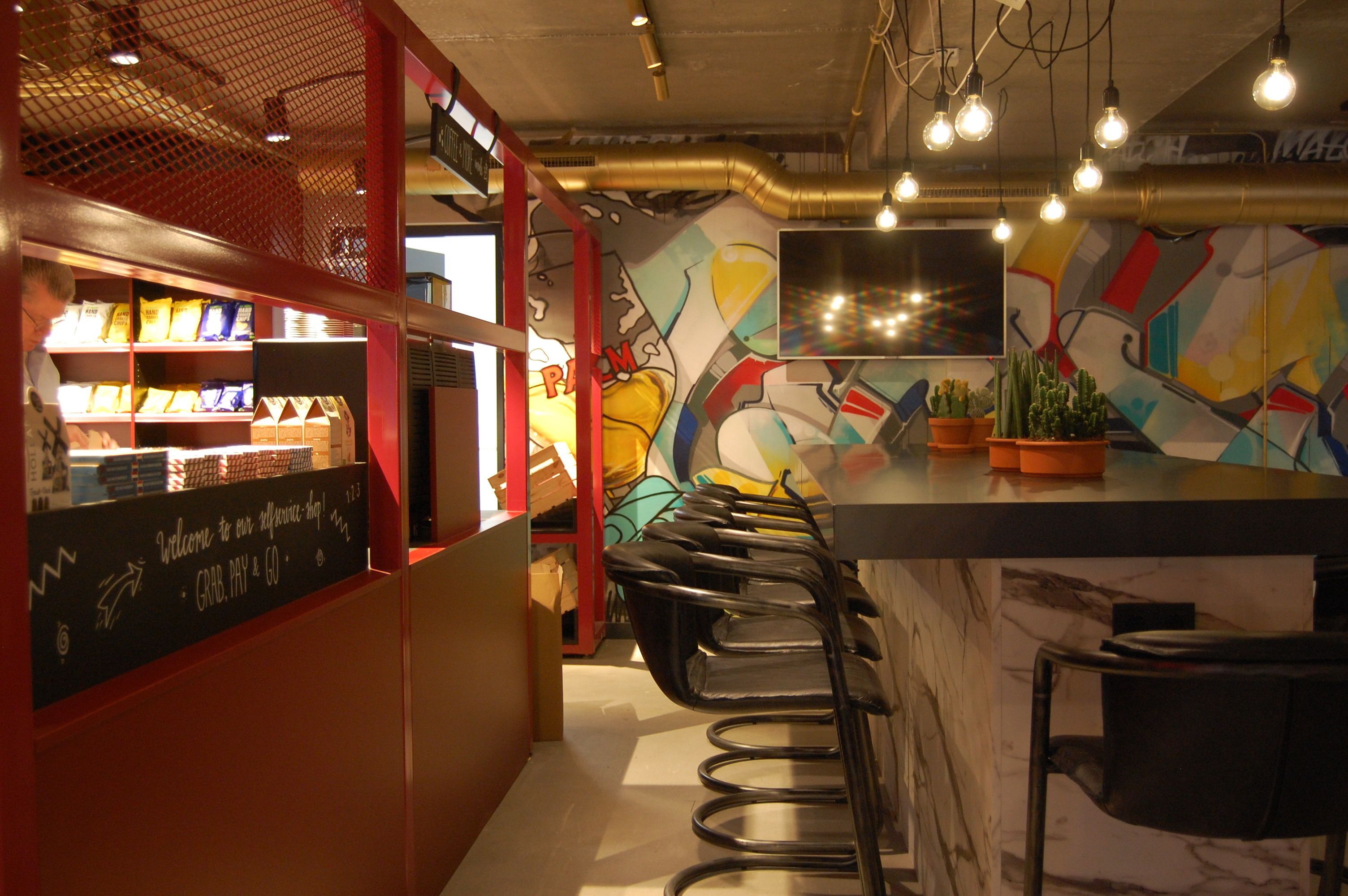 Un espace bar avec un comptoir, des tabourets et une fresque murale.