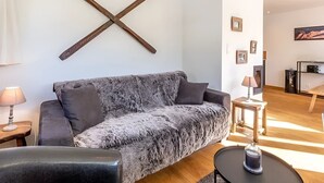 Una sala de estar moderna con un sofá gris, una mesa de centro y piso de madera.