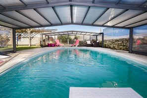 Una piscina al aire libre, una piscina climatizada