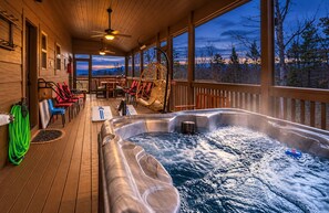 A wooden deck with a hot tub, chairs, and a view of the landscape. - Hot Tub, Fire Pit, Views, Wheelchair Accessible Retreat (Sevierville)