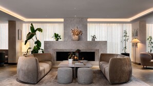 Una sala de estar moderna con chimenea, dos sofás, una mesa de centro y diversas plantas.