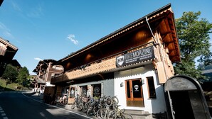 A building with a sign reading "BIKEMORZINE" and a row of bicycles parked outside. - Hideout Hostel (Morzine)