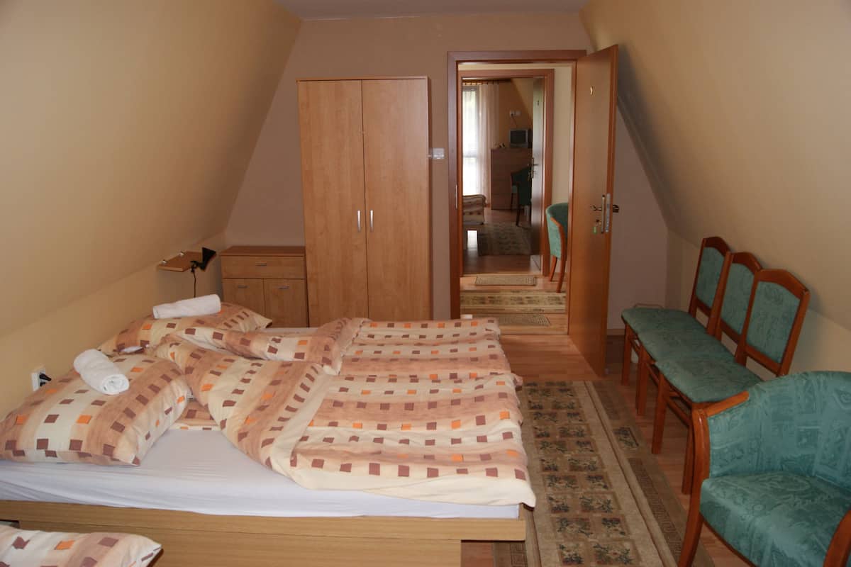 A bedroom with a bed, a wardrobe, a desk, and a chair.