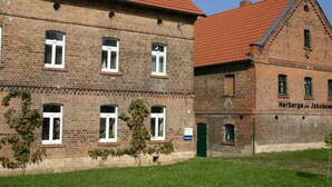A historic brick building with multiple windows and a red-tiled roof. - Herberge am Jakobsweg (Weissenfels)