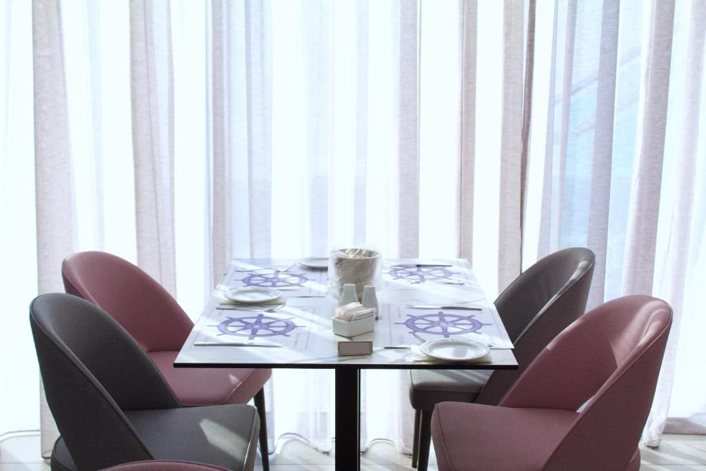 Une table à manger dressée pour quatre personnes, avec une nappe ornée d’une étoile de David, entourée de chaises.
