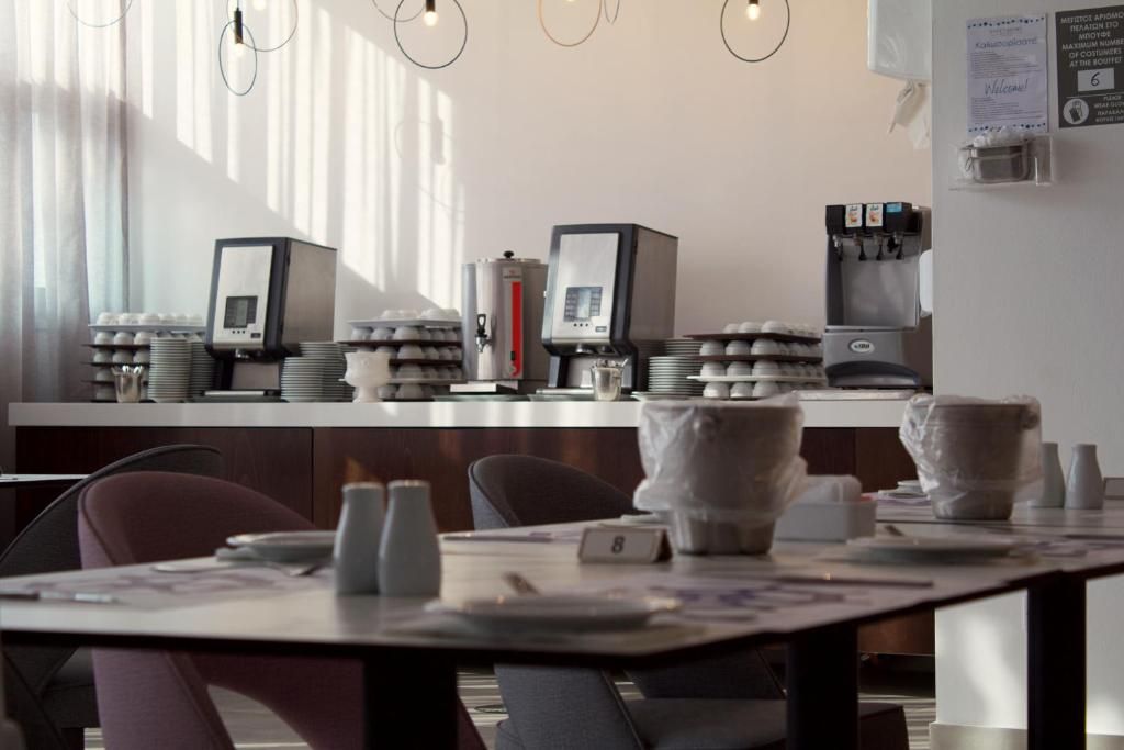 Un restaurante con mostrador, cafeteras y zona de estar.