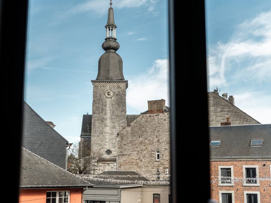 A view of a church tower with a clock, surrounded by buildings.