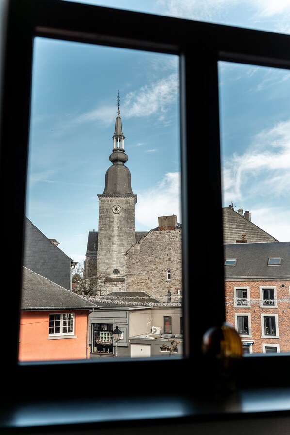 Een kerktoren met een klok, omgeven door gebouwen.