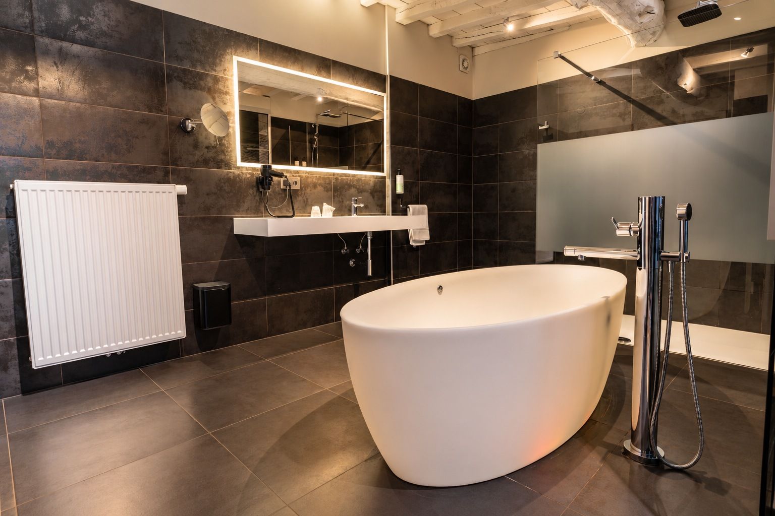 A modern bathroom with a freestanding bathtub, a large mirror, and a shower area.