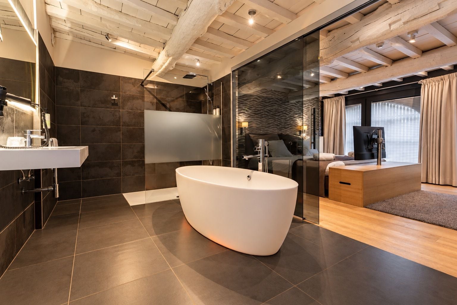 Un baño moderno con una bañera independiente, cabina de ducha de vidrio y tocador con lavamanos.