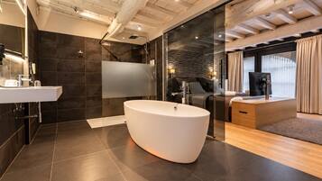 Un baño moderno con una bañera independiente, cabina de ducha de vidrio y tocador con lavamanos.