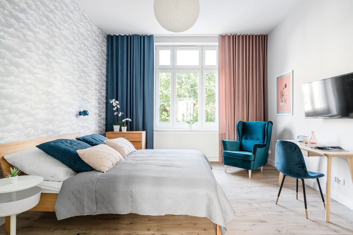 A modern bedroom with a bed, a desk, and a chair.
